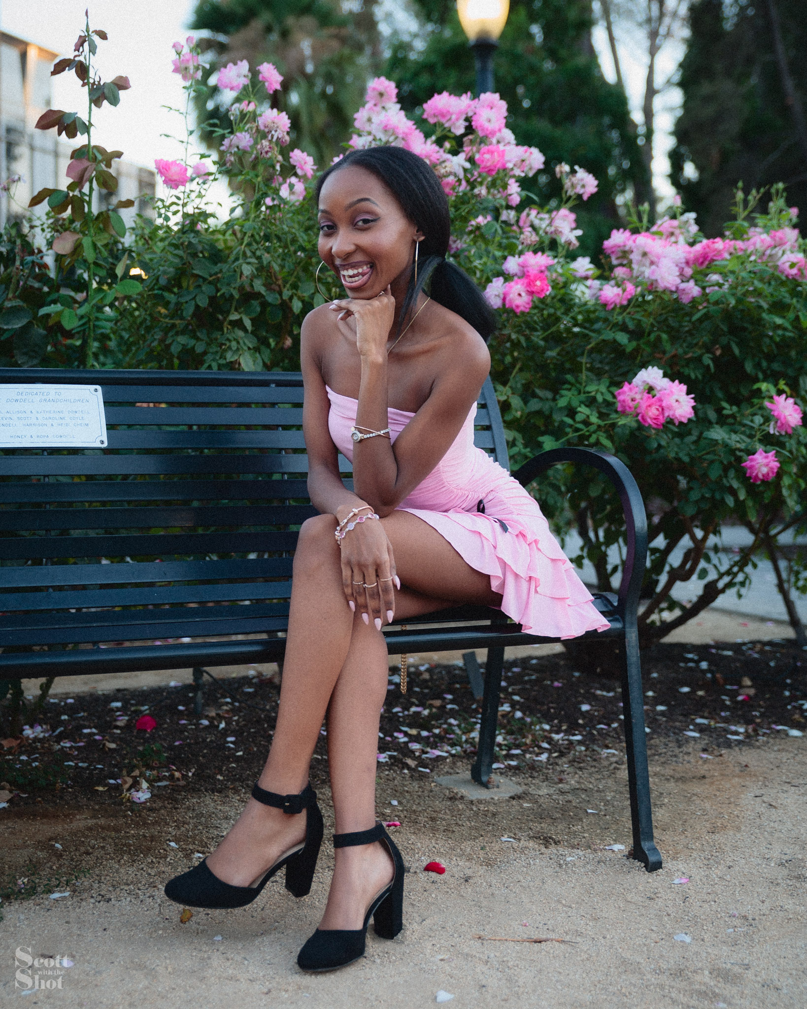 Yasmeen smiling in a pink dress in a rose garden